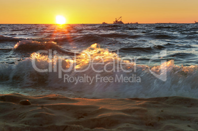 sunset on the sea, the waves beat against the breakwater, the sea at dawn, the ships on the horizon