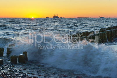 sunset on the sea, the waves beat against the breakwater, the sea at dawn, the ships on the horizon