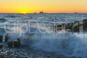 sunset on the sea, the waves beat against the breakwater, the sea at dawn, the ships on the horizon