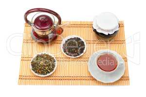 Teapot, cup of tea, jam jar and tea leaves isolated on white bac