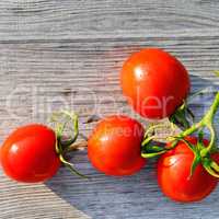 Red tomatoes on wooden surface.