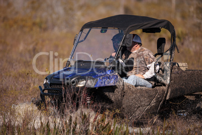 Men go off-roading in a swamp with an ATV