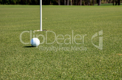 Golf ball and flag on Lush green grass