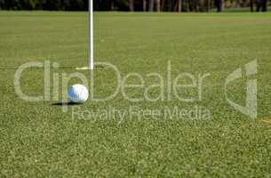 Golf ball and flag on Lush green grass
