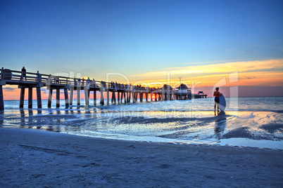 Surfer man skimboard silhouette Naples Pier