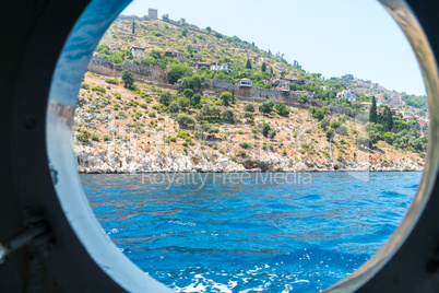 The view from the window of a marine vessel on the stone walls of the old coastal fortress of Alanya
