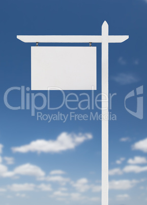 Blank Real Estate Sign Over A Blue Sky with Clouds.