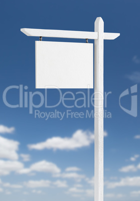 Blank Real Estate Sign Over A Blue Sky with Clouds.