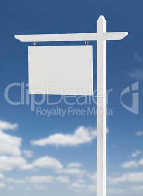 Blank Real Estate Sign Over A Blue Sky with Clouds.