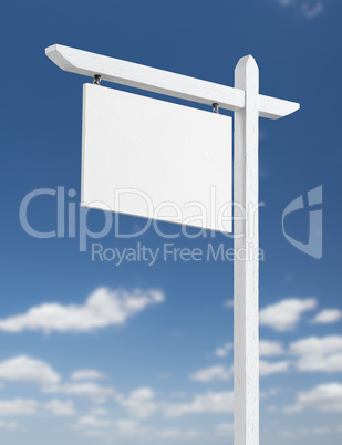 Blank Real Estate Sign Over A Blue Sky with Clouds.