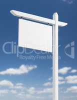 Blank Real Estate Sign Over A Blue Sky with Clouds.