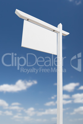 Blank Real Estate Sign Over A Blue Sky with Clouds.