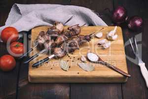 pieces of roasted pork meat on iron skewers
