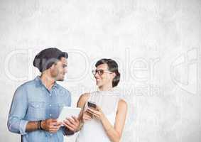 Man and woman holding tablet and phone with bright background