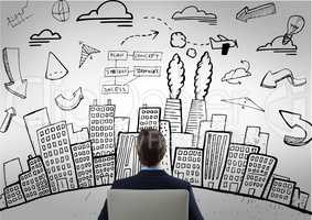 Business man sitting looking at doodle of skyscrapers