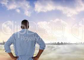 Man looking out at colourful city skyline with smoke in front of him