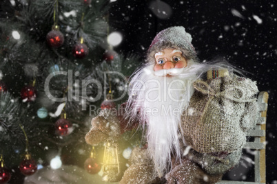 Santa Claus Outdoors Beside Christmas Tree in Snowfall Carrying