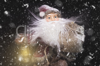 Santa Claus Outdoors Beside Christmas Tree in Snowfall Carrying