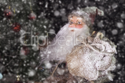 Santa Claus Outdoors Beside Christmas Tree in Snowfall Carrying