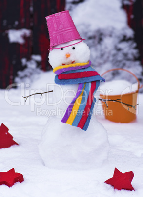 snowman with a bucket on his head on white snow