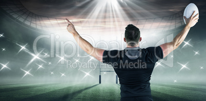 Composite image of rugby player celebrating with the ball