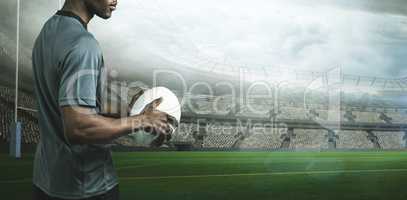 Composite image of sportsman holding rugby ball