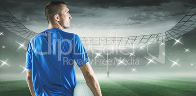 Composite image of rugby player looking away while holding ball