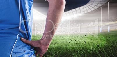 Composite image of rugby player looking away while holding ball