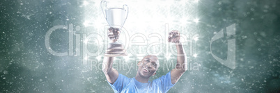 Happy sportsman looking up and cheering while holding trophy