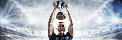 Composite image of portrait of successful rugby player holding trophy