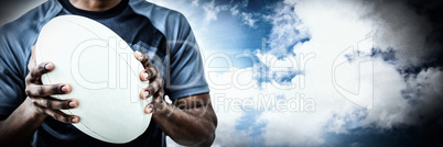 Composite image of mid section of sportsman holding rugby ball