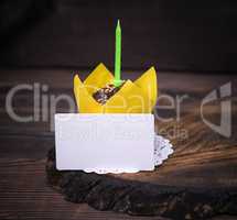 paper business card and chocolate cupcake with a green candle
