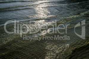 Tranquil ocean, ripples and sand.