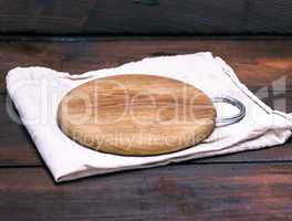 empty round wooden board on a gray napkin