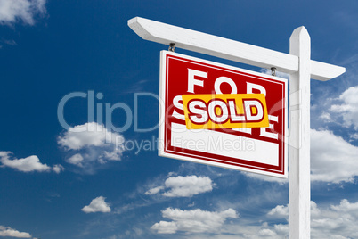 Left Facing Sold For Sale Real Estate Sign Over Blue Sky and Clo
