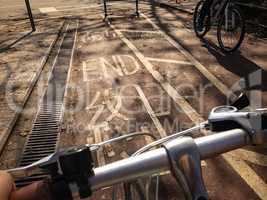 head of bike, bicycle lane with word END on floor