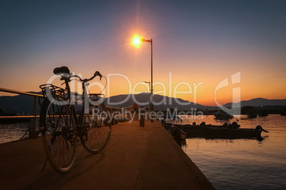 Retro bicycle, pier, fence and gradient sunset