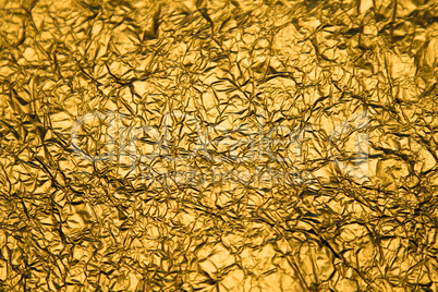 Golden shiny abstract metallic crumpled paper background