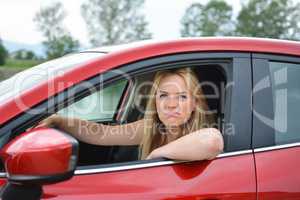 Young blonde girl  in red car mocking at somebody