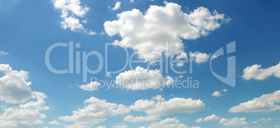 Light cumulus clouds against the blue sky. Wide photo.