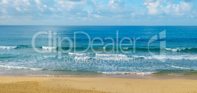 Deserted sandy beach of the Indian Ocean. In the blue sky cumulu