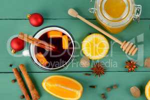 Hot red mulled wine on wooden background with orange slice, anis