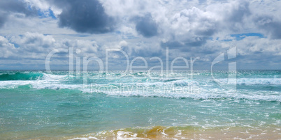 Sandy beach of the tropical ocean and the overcast sky with dram