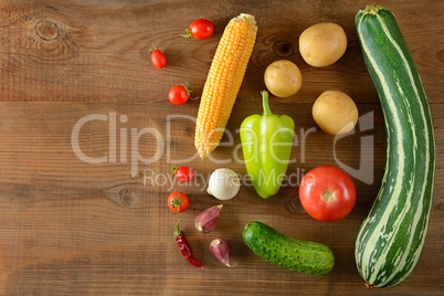 A set of vegetables laid out on a wooden table. Top view. Free s