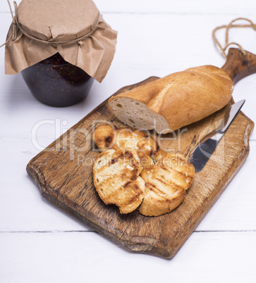 pieces of white bread on a brown wooden board and raspberry jam