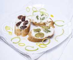 sandwiches with creamy cheese, sausage, olives and dill