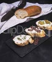 sandwiches with creamy white cheese, sausage, olives and dill