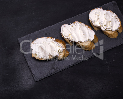 three sandwiches with creamy white cheese