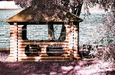 A beautiful gazebo on a picturesque Bank of the river. The effect of infrared film.