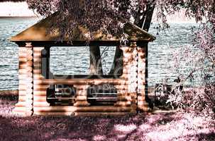 A beautiful gazebo on a picturesque Bank of the river. The effect of infrared film.
